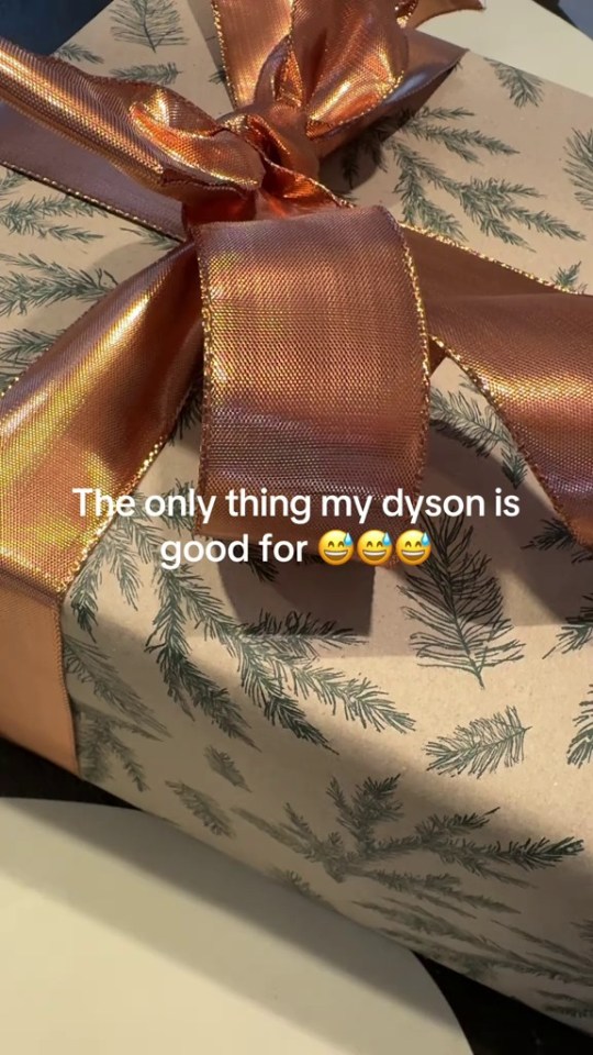 A Christmas gift wrapped in brown paper with a copper ribbon, curled with a Dyson.