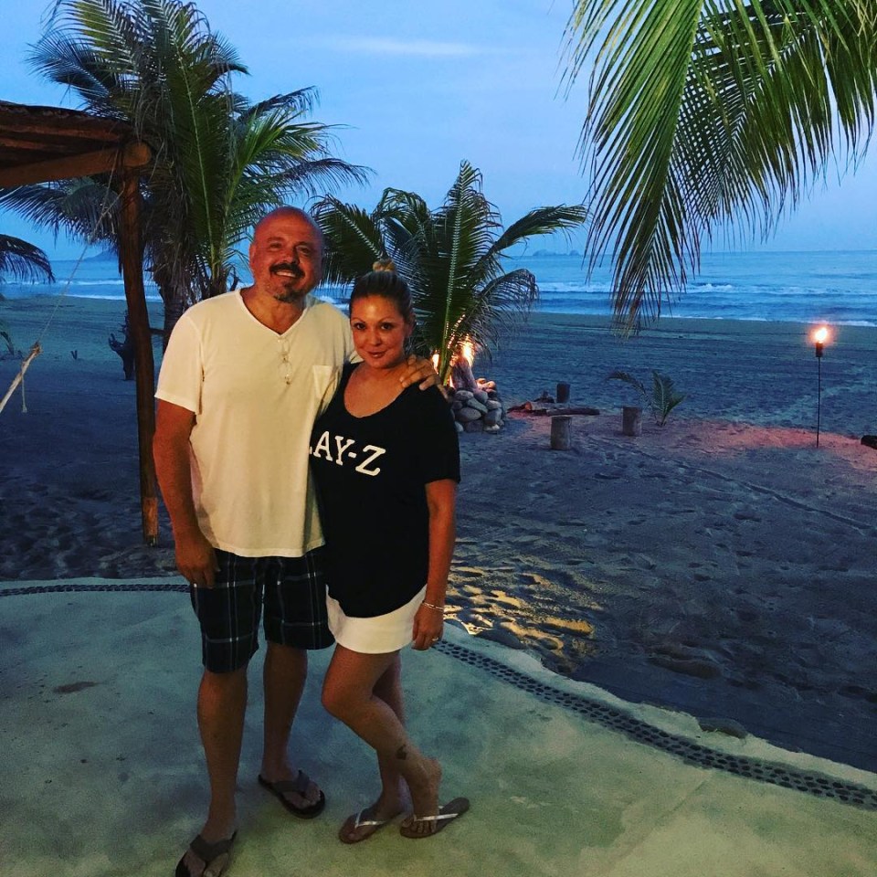 Walter Afanasieff and his wife Katie Cazorla on a beach at dusk.