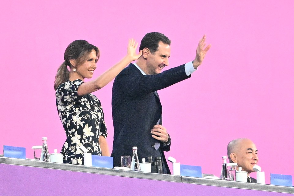 Bashar al-Assad and his wife Asma al-Assad wave at the 2022 Asian Games opening ceremony.