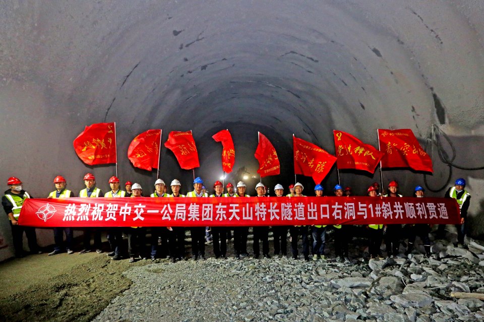 Workers celebrate the breakthrough of a tunnel in the east Tianshan mountain