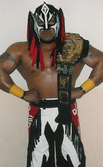 Rey Misterio Sr. in wrestling attire and championship belt.