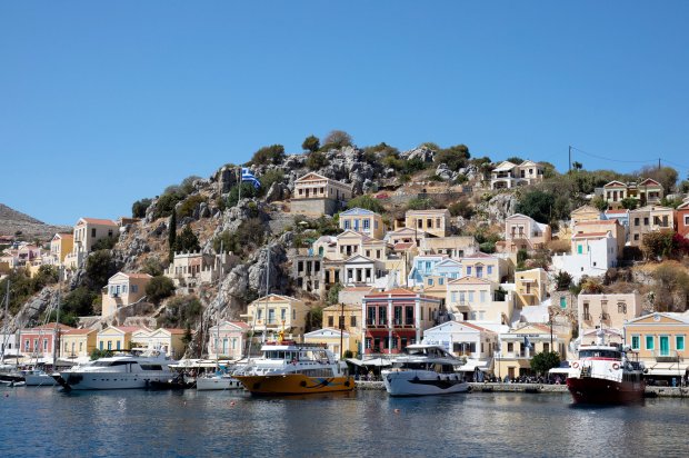 Colorful houses on a hillside overlooking a harbor with boats.