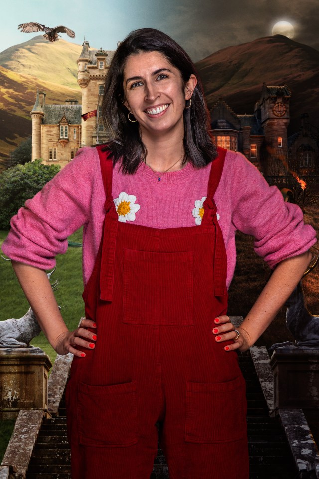 Portrait of a smiling woman wearing red overalls and a pink sweater, set against a backdrop of two castles and a moonlit landscape.