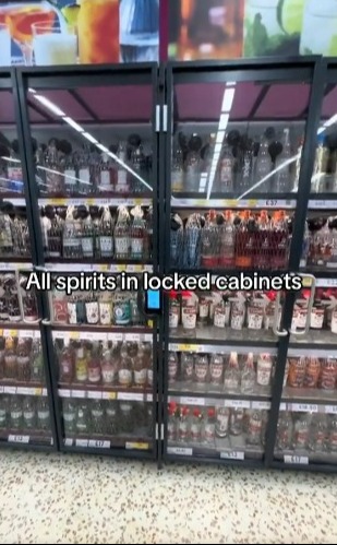 Liquor store display with spirits in locked cabinets.