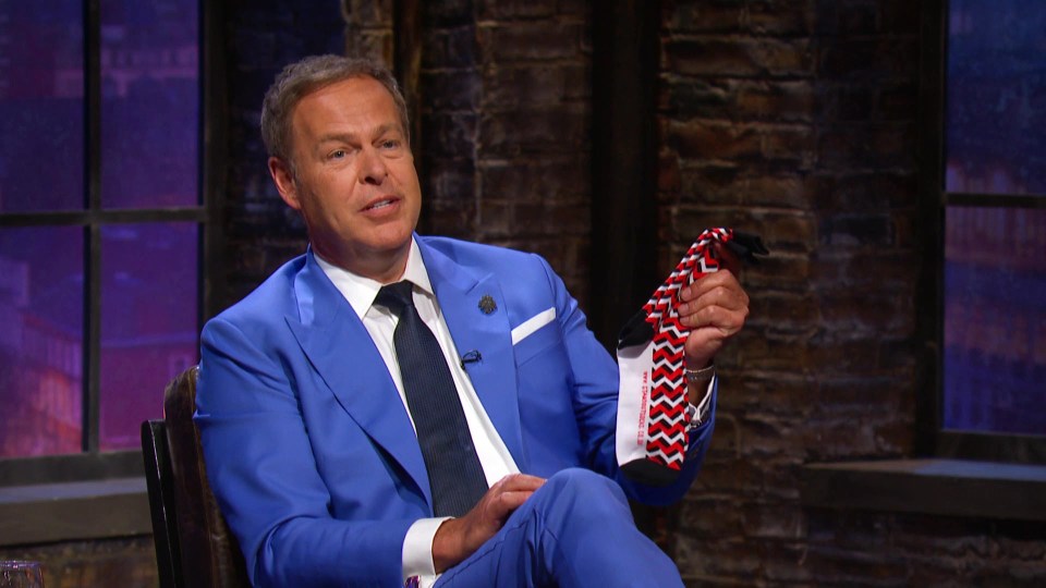 Peter Jones on Dragons' Den holding a pair of socks.