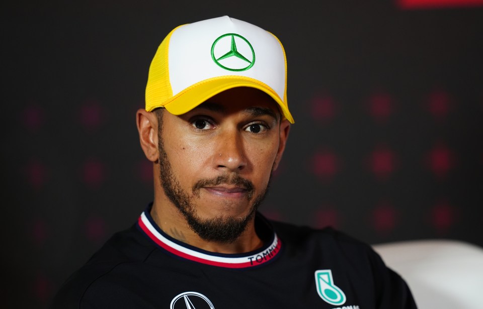 Lewis Hamilton wearing a yellow and white cap.