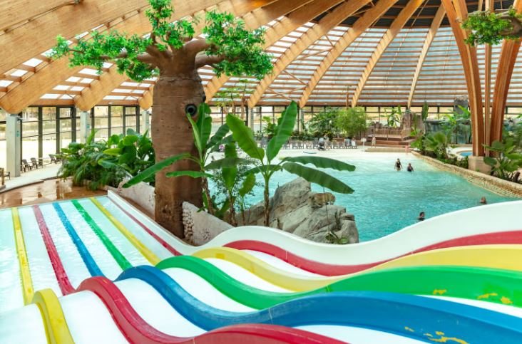 Indoor water park with multiple slides and a large pool.