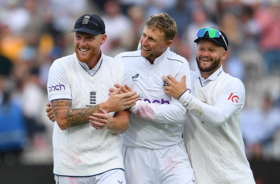 Three England cricket players celebrating a wicket.