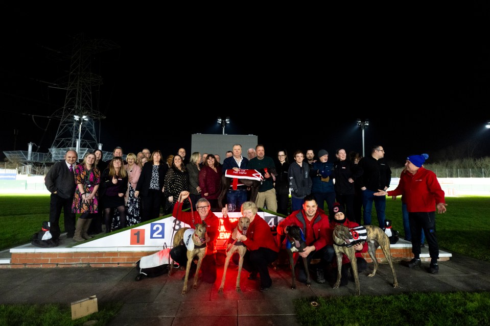 Group photo of staff and greyhounds at Crayford Greyhound Stadium on its final night.