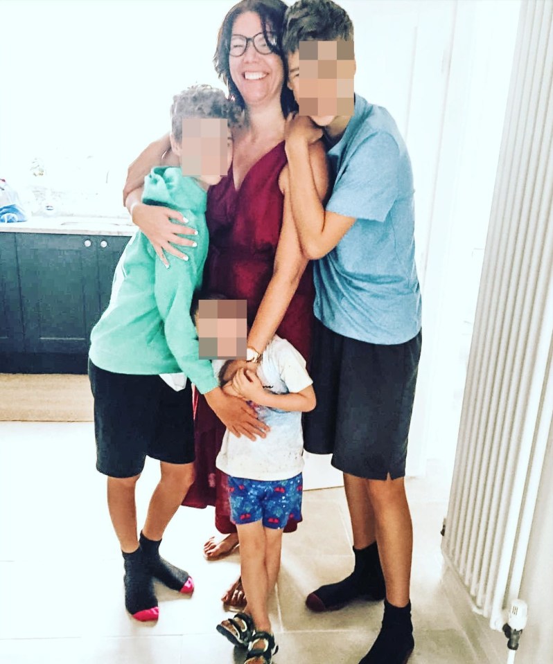 Woman hugging her three children.