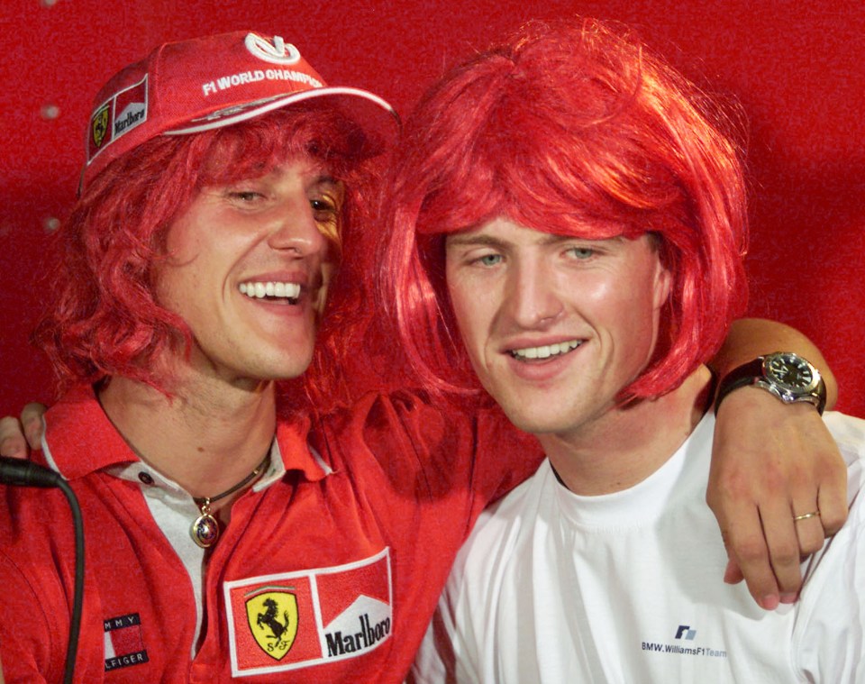 Michael Schumacher and his brother Ralph wearing red wigs after a Formula One race.