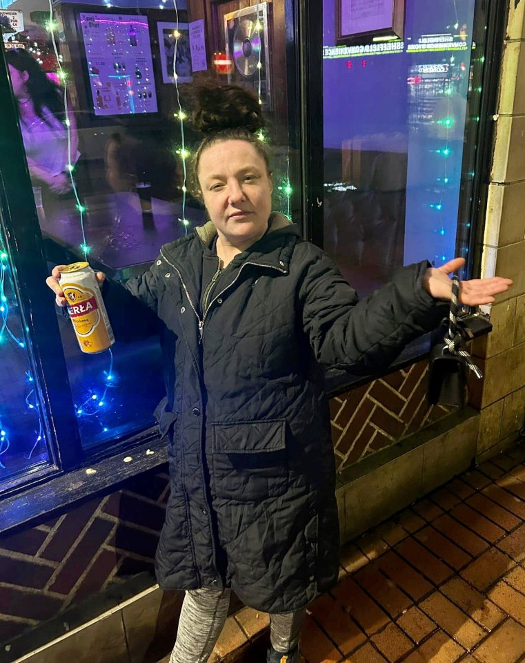 Woman holding a beer can outside at night.