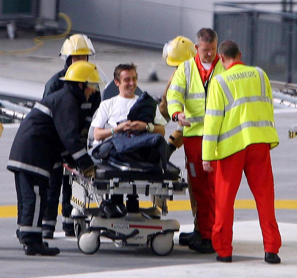 Richard Hammond on a stretcher, being helped by paramedics and firefighters.