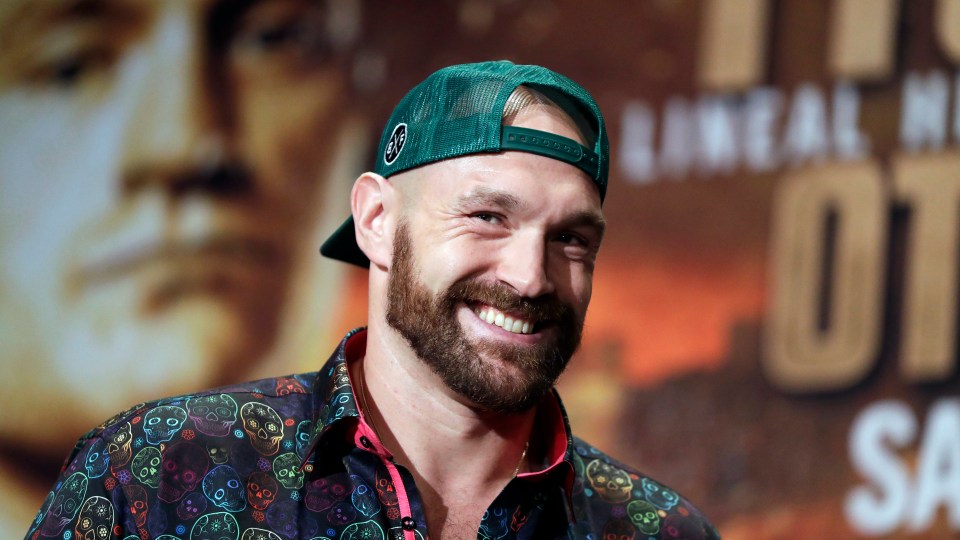 Tyson Fury smiling and wearing a green baseball cap.