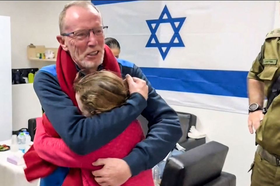 A father embraces his young daughter in a hospital after her release from Hamas captivity.