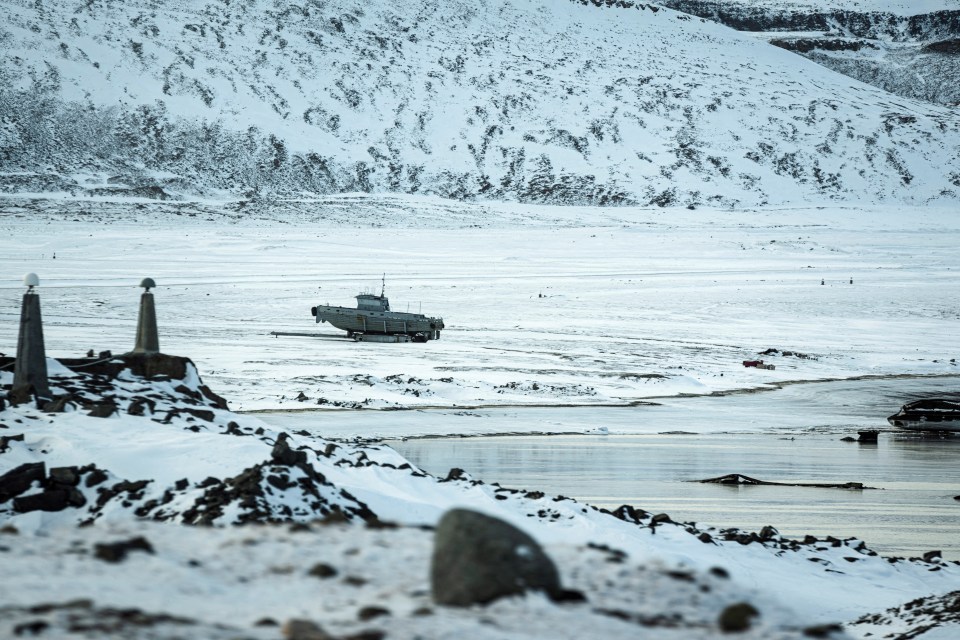 A boat sits on the snow-covered ground near Pituffik Space Base in Greenland.