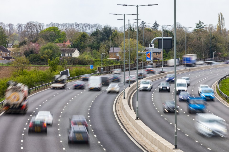 Blurred photo of vehicles traveling on a multi-lane highway.