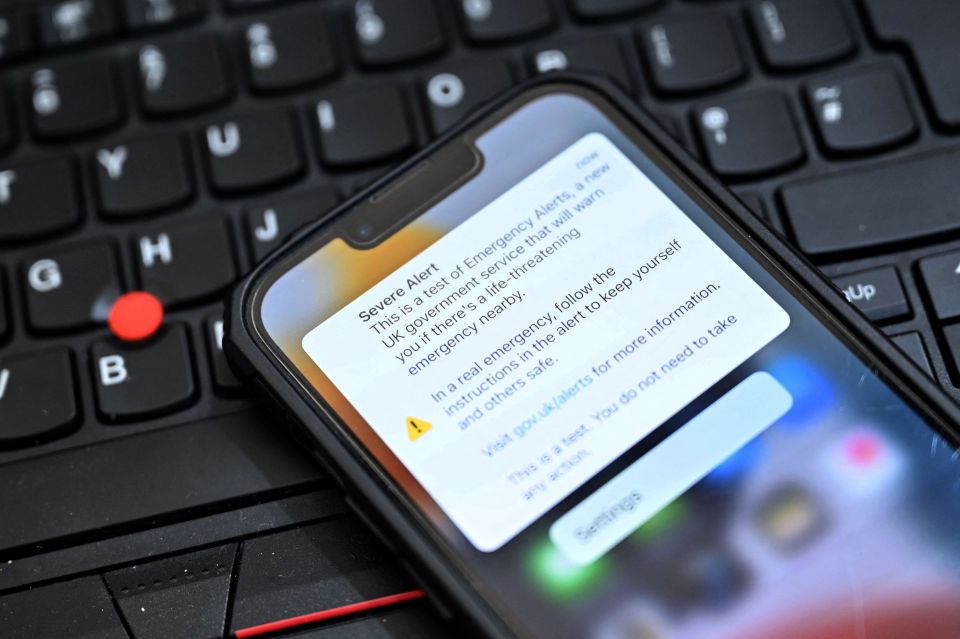 Smartphone displaying a UK government emergency alert test message.