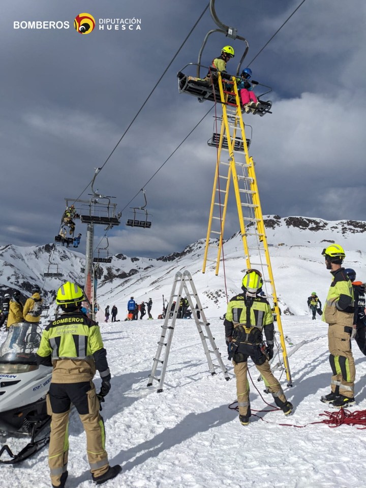 Firefighters rescue skiers from a chairlift at a ski resort.