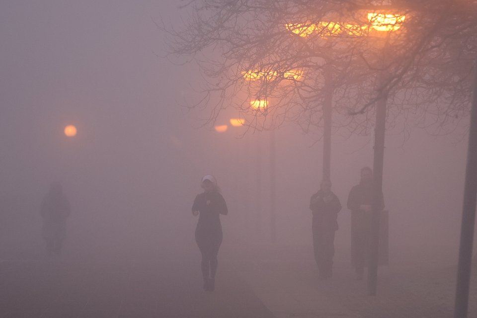 People walking in thick fog.