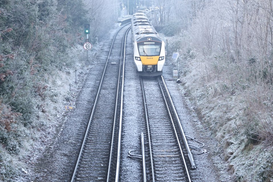 Train traveling through a frost-covered landscape.