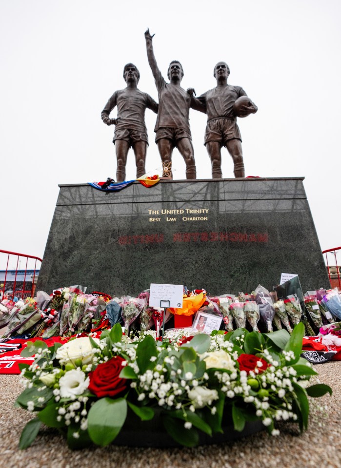 Flowers and tributes at the statue of Manchester United's "United Trinity."