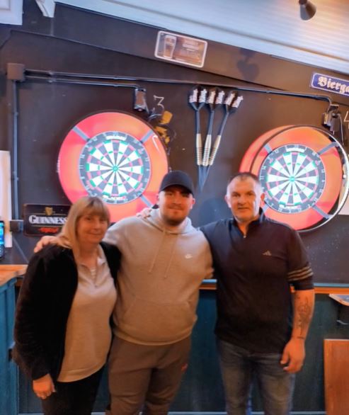 World darts champion Luke Littler with his family at a darts tournament.