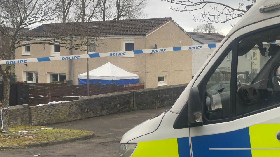 Crime scene with police tape and a forensic tent outside a house.