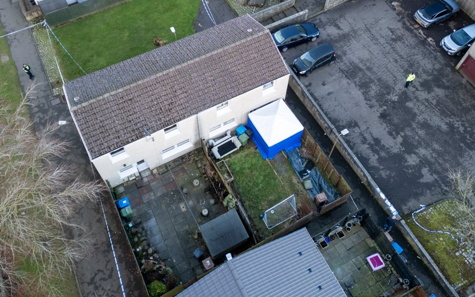 Aerial view of a crime scene with police tape and a forensic tent in a residential backyard.