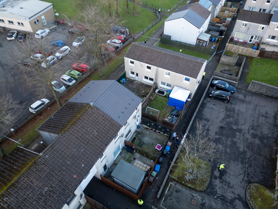 Aerial view of a crime scene in West Calder, Scotland, with police investigating the deaths of a man and a child.