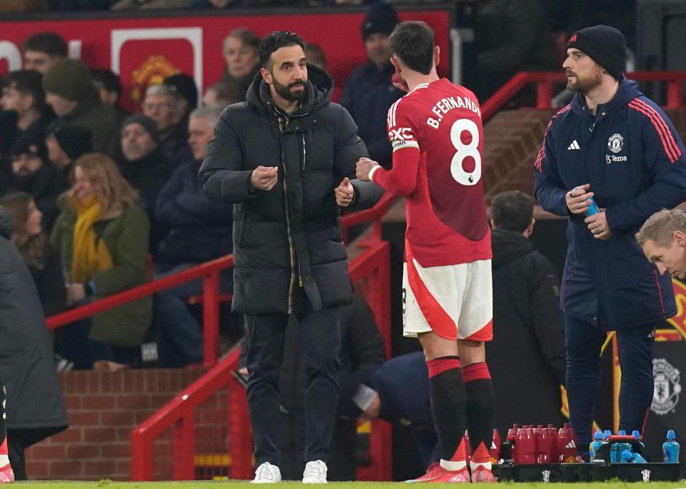 Ruben Amorim, manager of Manchester United, speaks with Bruno Fernandes during a Premier League match.