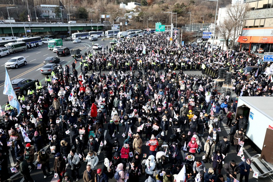 Pro-Yoon supporters gather near his residence to "defend" against the authorities trying to arrest him