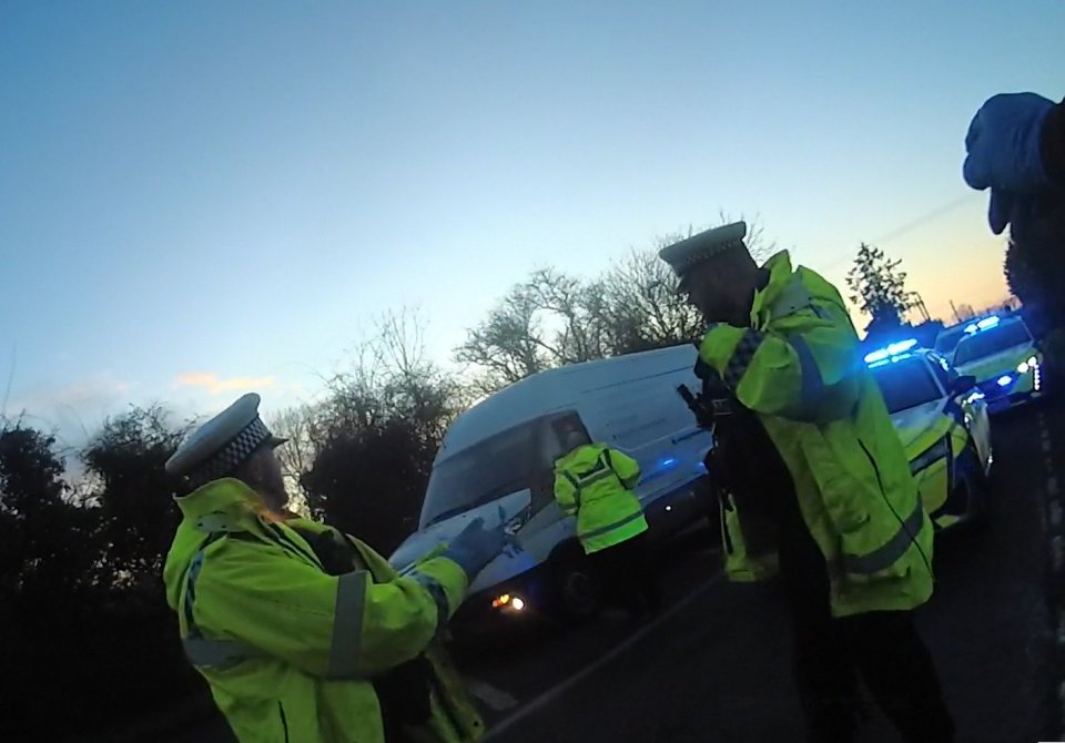 Police officers stopping a refrigerated lorry.