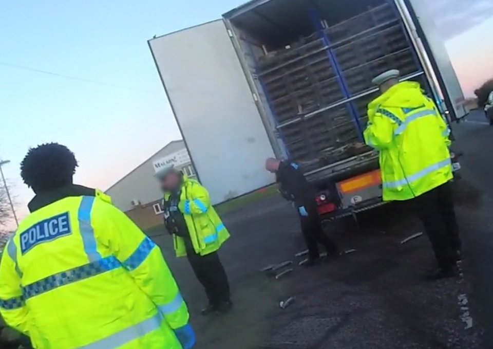 Police officers rescue seven people from a refrigerated lorry.