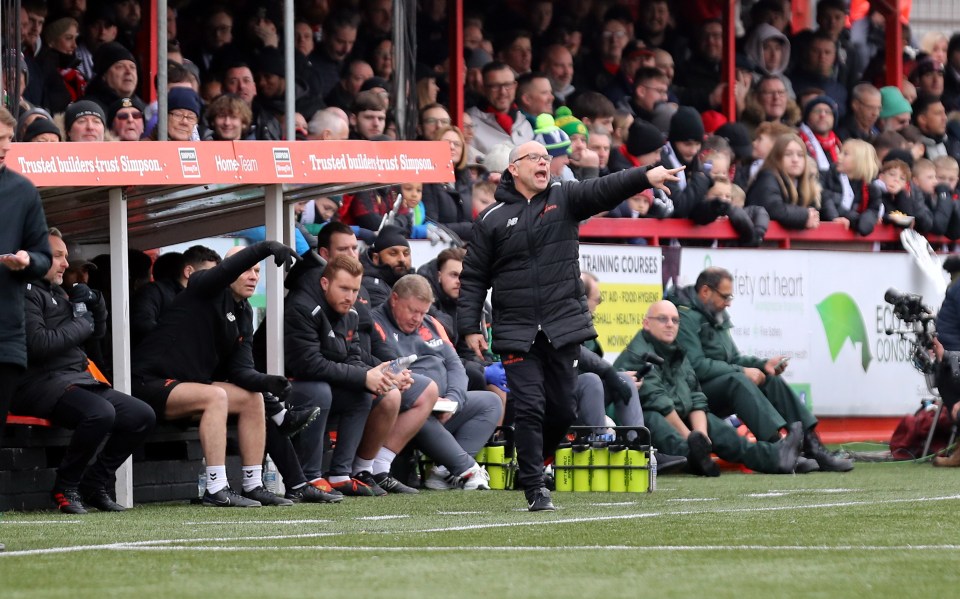 Soccer coach instructing his team from the bench.