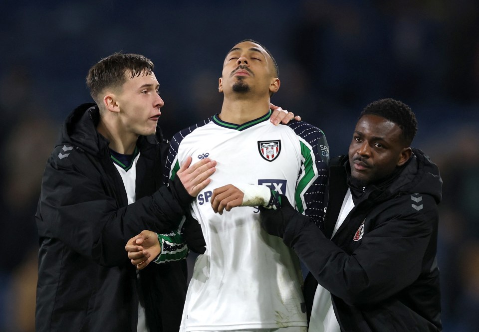 Sunderland's Wilson Isidor looking dejected, supported by teammates.