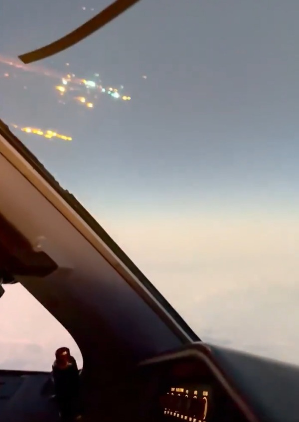 City lights viewed from an airplane cockpit.