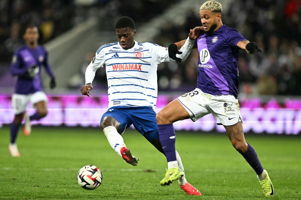 Two soccer players vying for the ball.