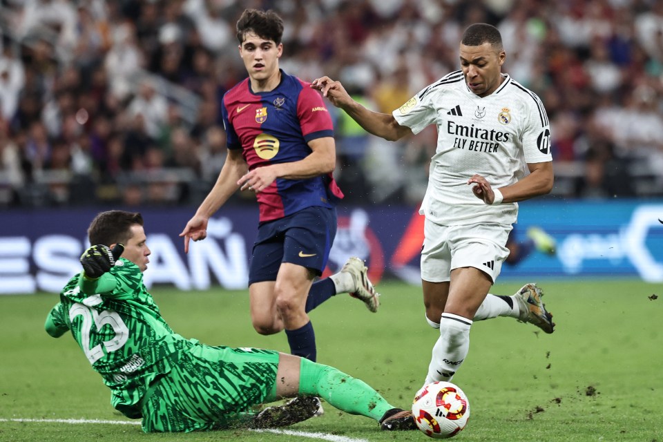 Soccer goalie diving for the ball as a player runs past.