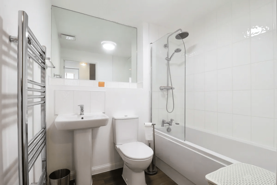 Small white bathroom with shower, tub, toilet, and sink.