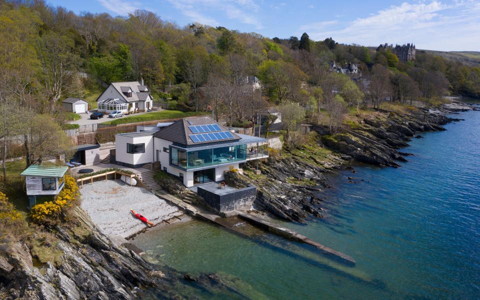 Aerial view of a modern house on a lochside in Scotland.