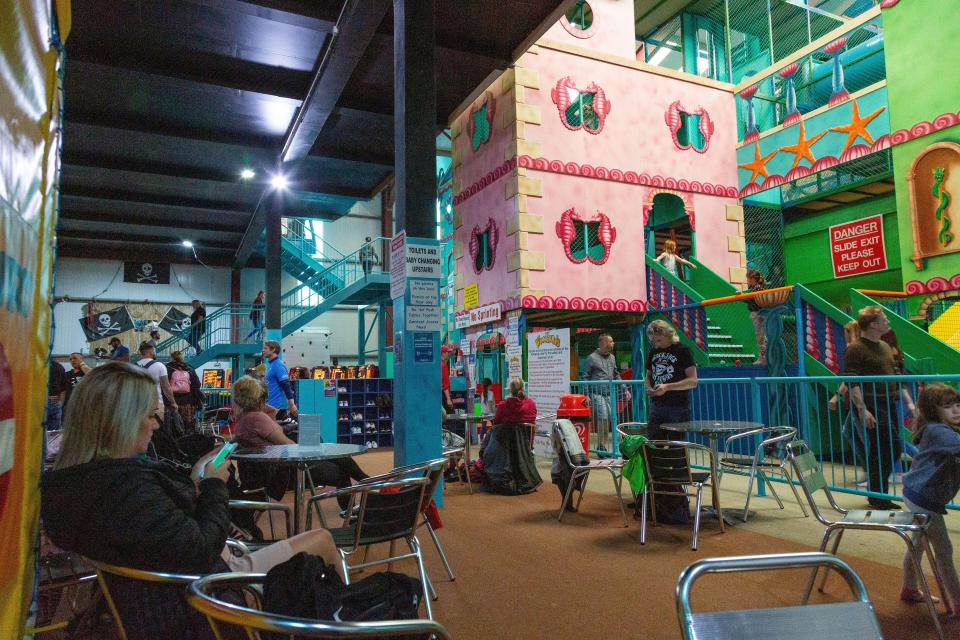 Indoor soft play area with seating for adults.