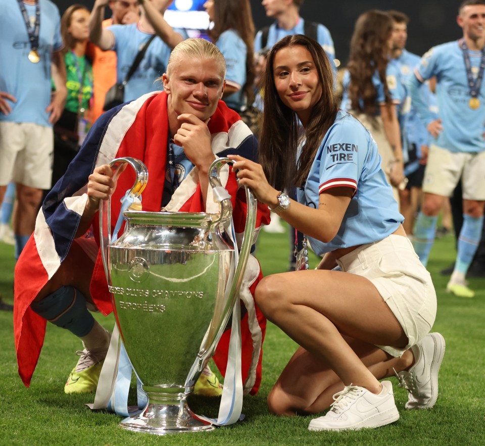 Erling Haaland and his girlfriend with the UEFA Champions League trophy.