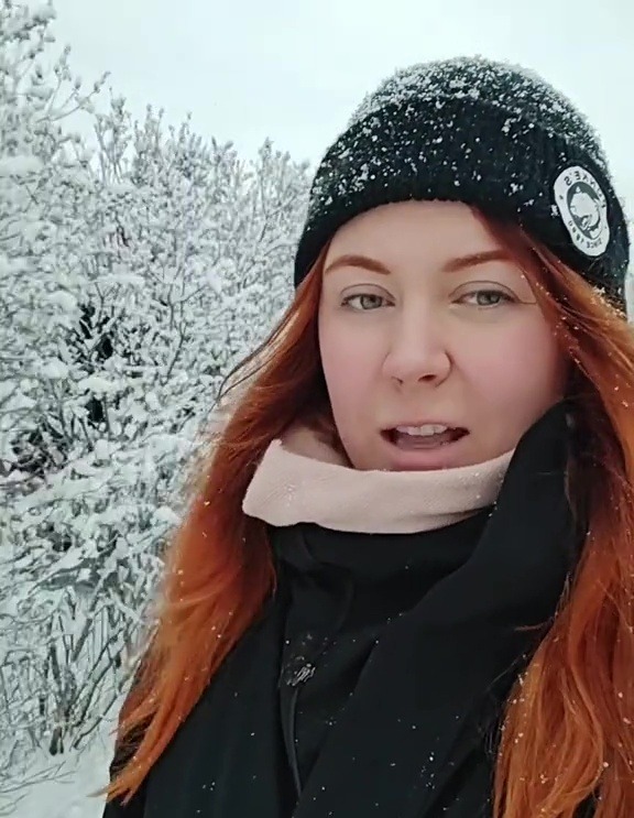 Woman in Finland wearing winter clothing in snowy landscape.