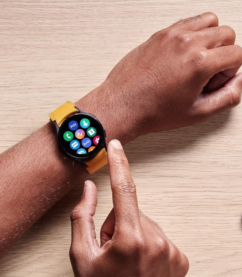 Person's hands interacting with a smartwatch and smartphone.