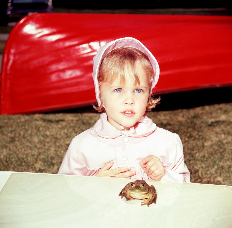 Young girl in pink bonnet with frog.