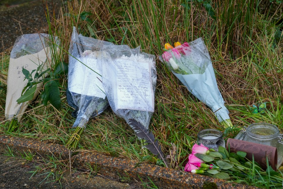 Flowers and handwritten notes left at a murder victim's home.