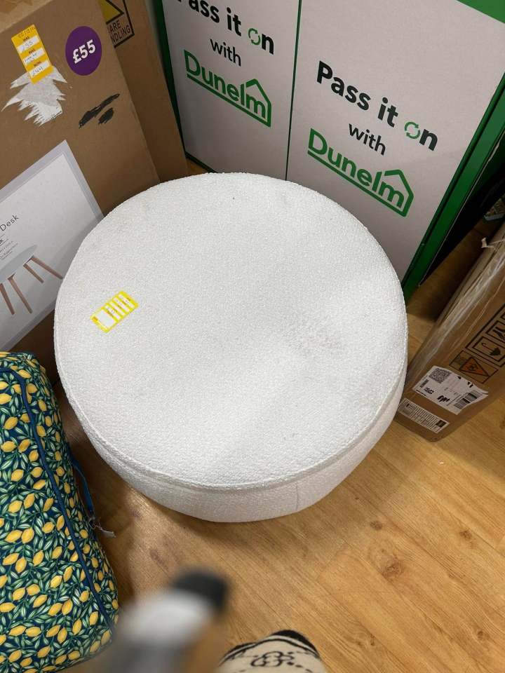 White round pouf on wood floor.