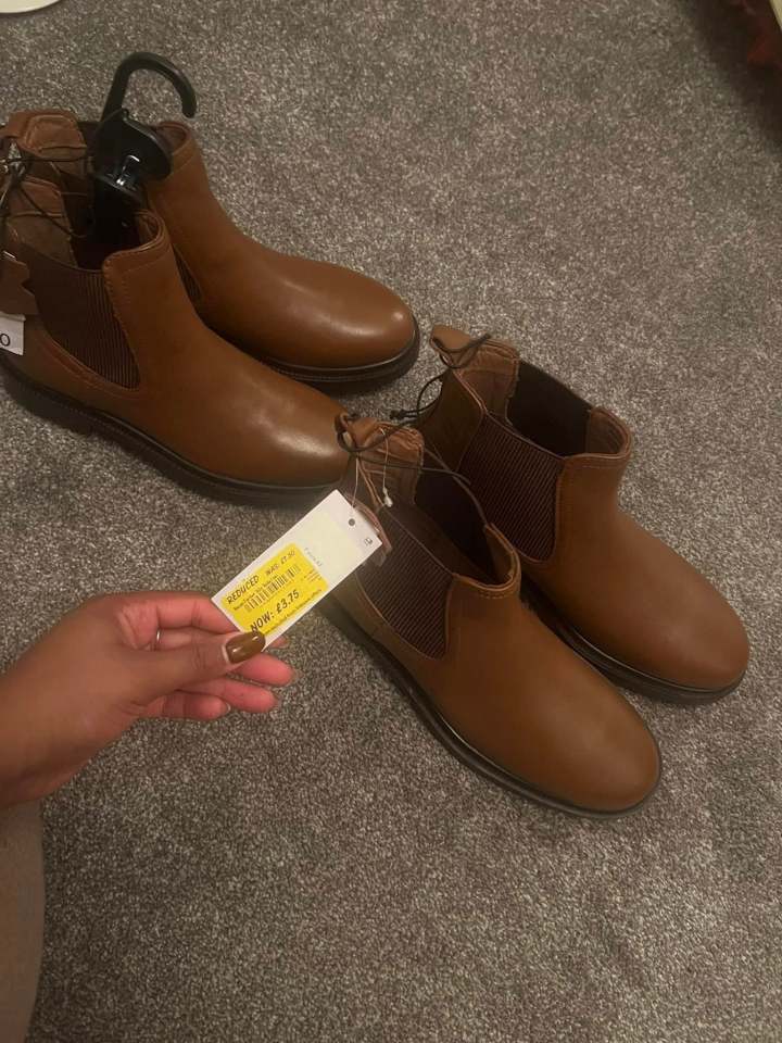 Brown ankle boots with price tag.