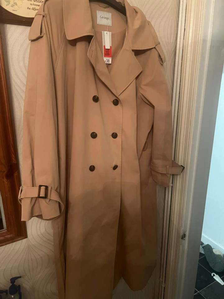 Beige trench coat with price tag.